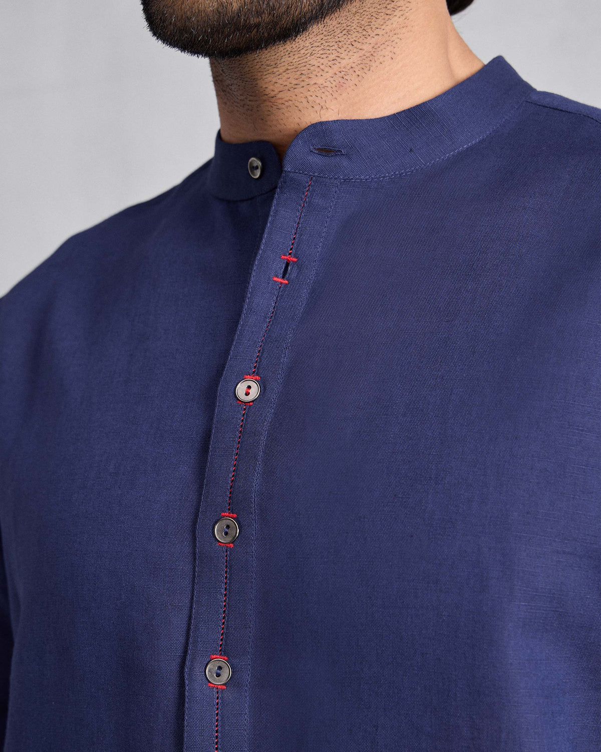 Close-up of an ink blue Chandni Chowk Kurta showing Nehru collar and red placket stitching.