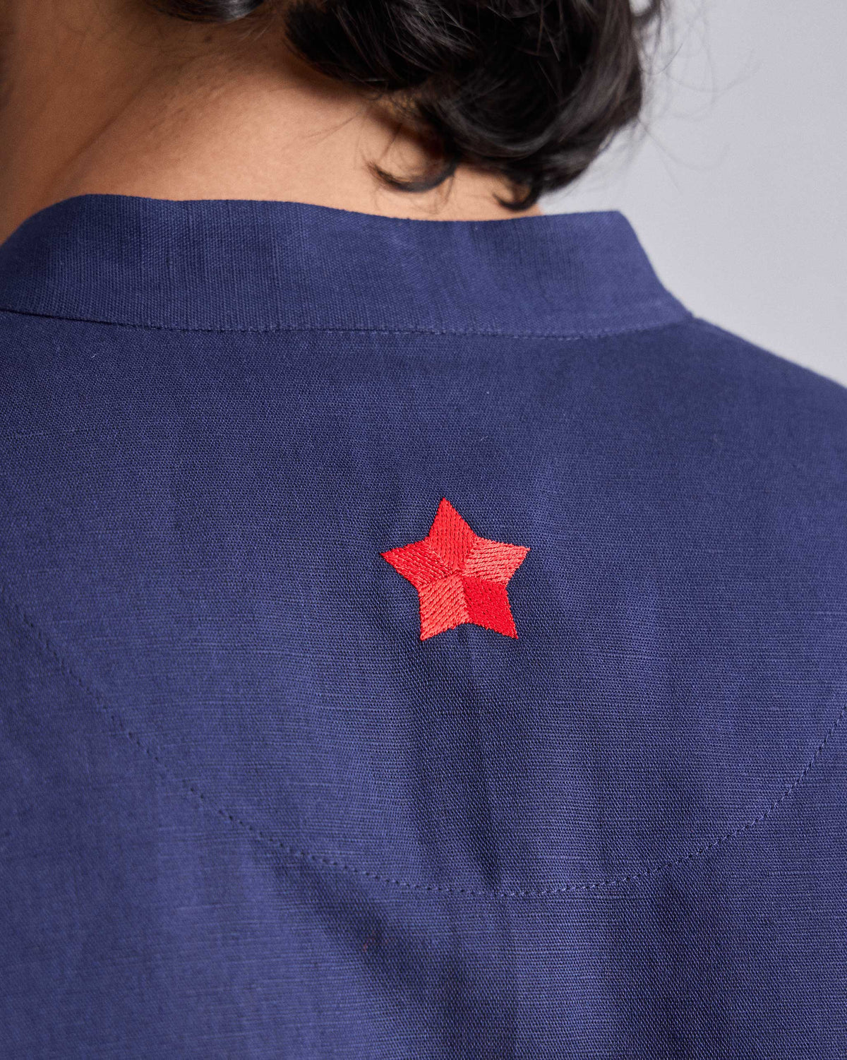 Close-up of the red embroidered star on the back of an ink blue Chandni Chowk Kurta.