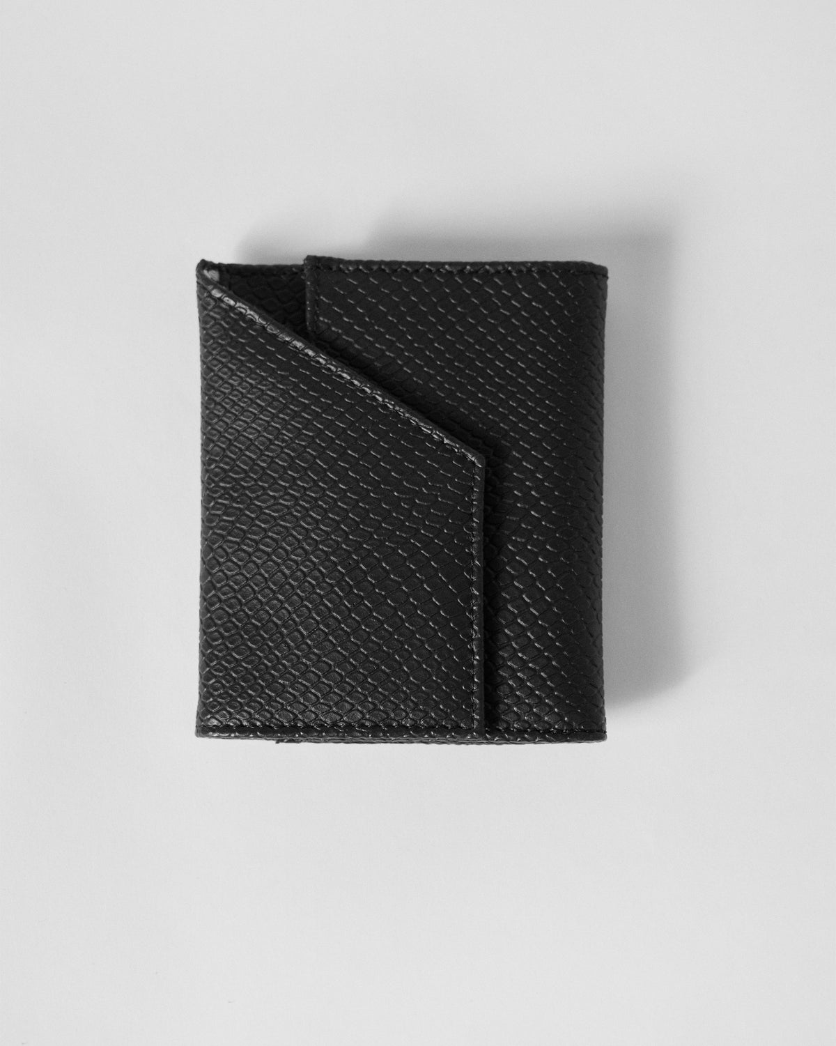 Black snake-grain tri-fold wallet showing the diagonal flap and tonal stitching.