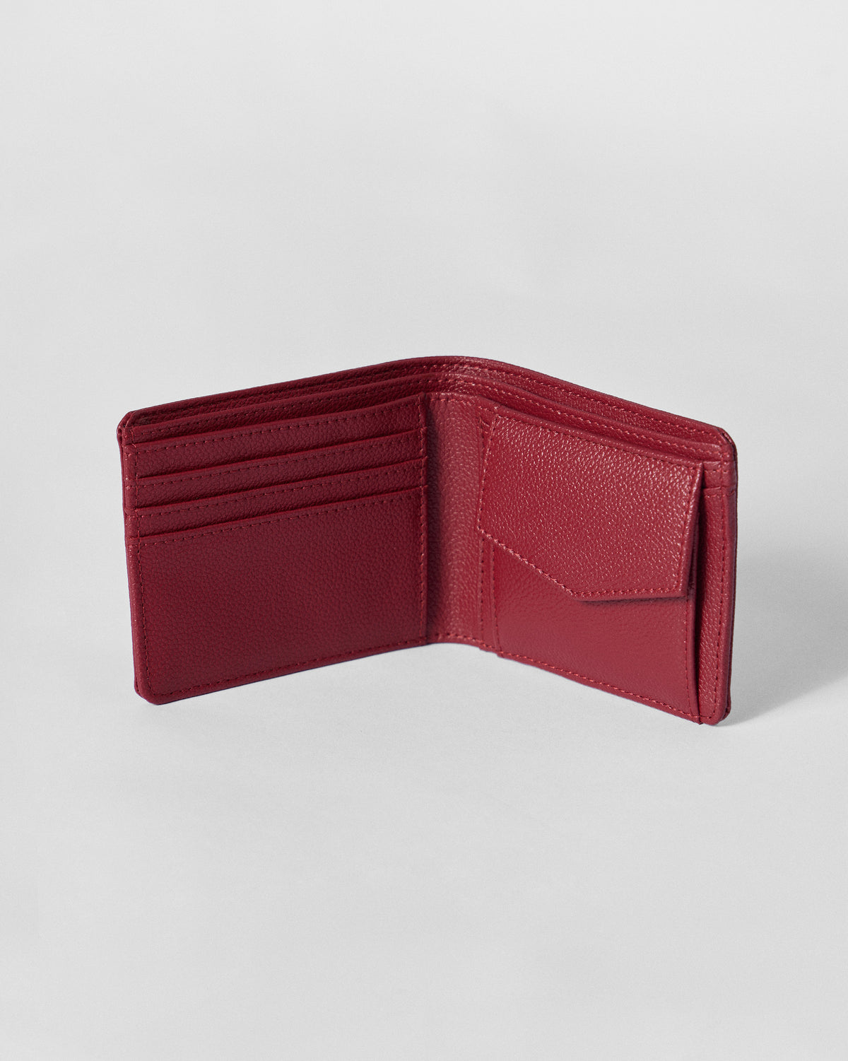 Open red bi-fold wallet showing card slots and a coin pouch.