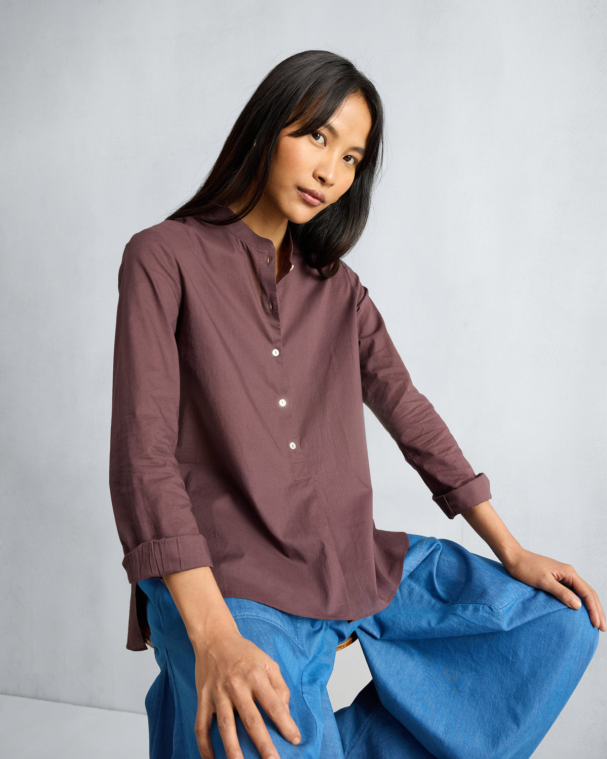 Person wearing a chocolate plum mandarin collar top.
