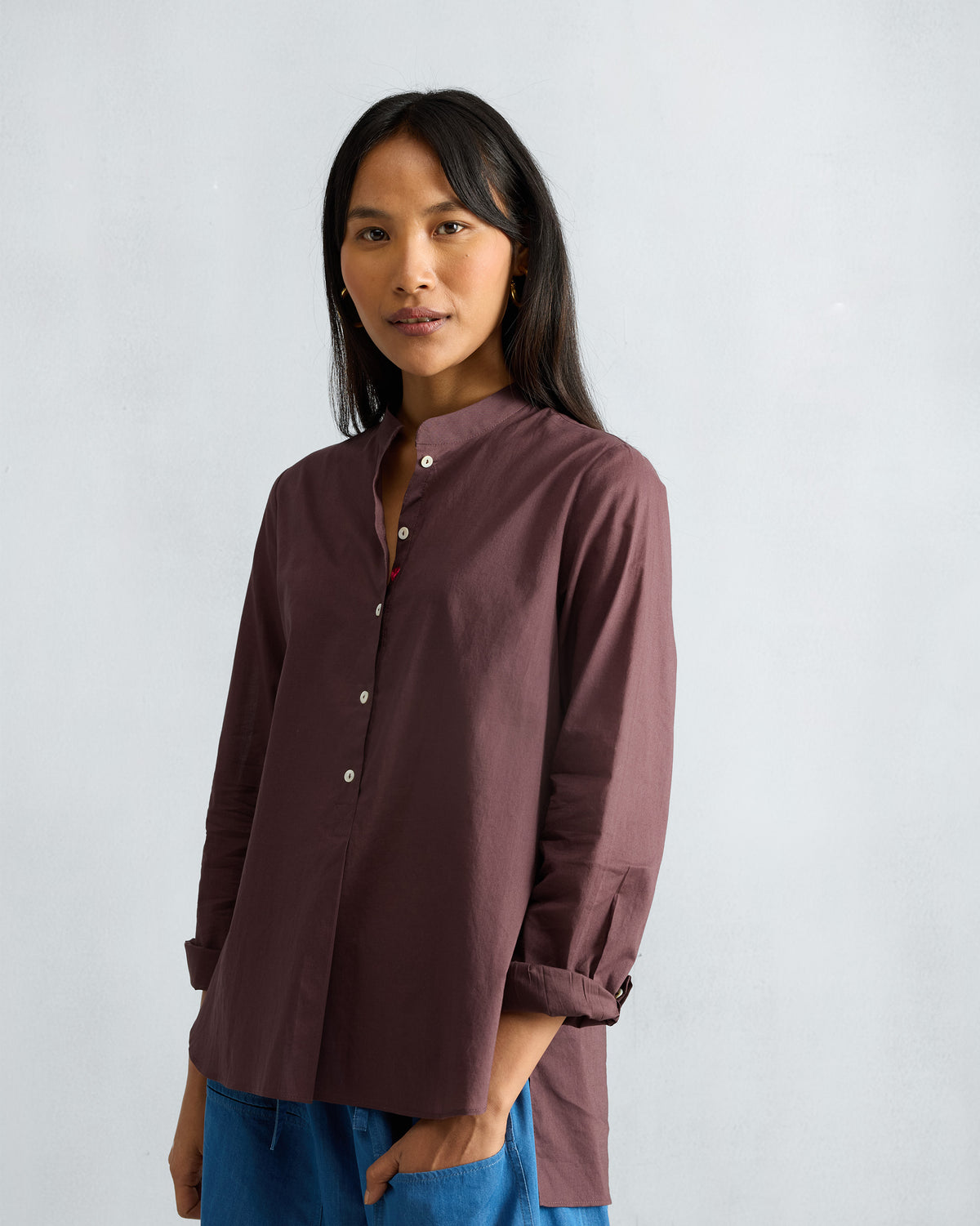 Person wearing a chocolate plum mandarin collar top.