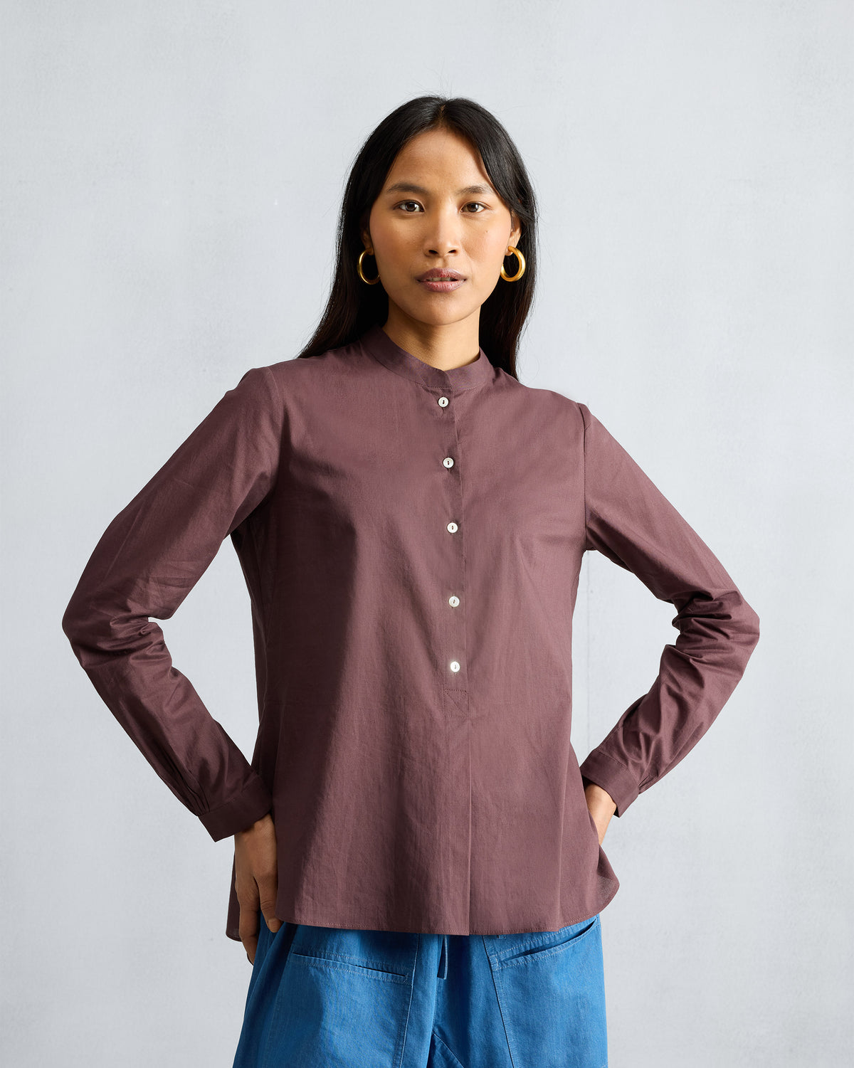 Person wearing a chocolate plum mandarin collar top.