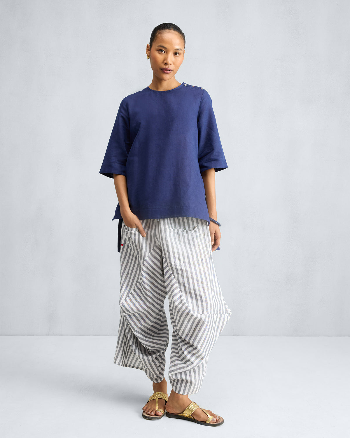 Person wearing an ink blue High Slit Top with a high-low hem and side slits.