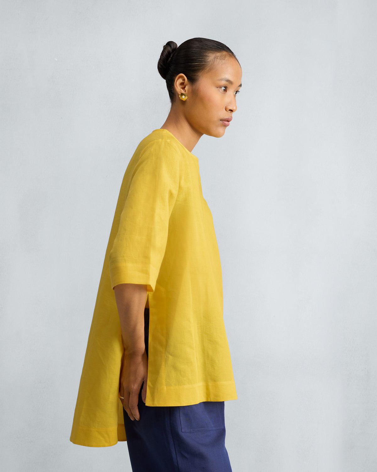Side view of a yellow High Slit Top showing the high side slits.