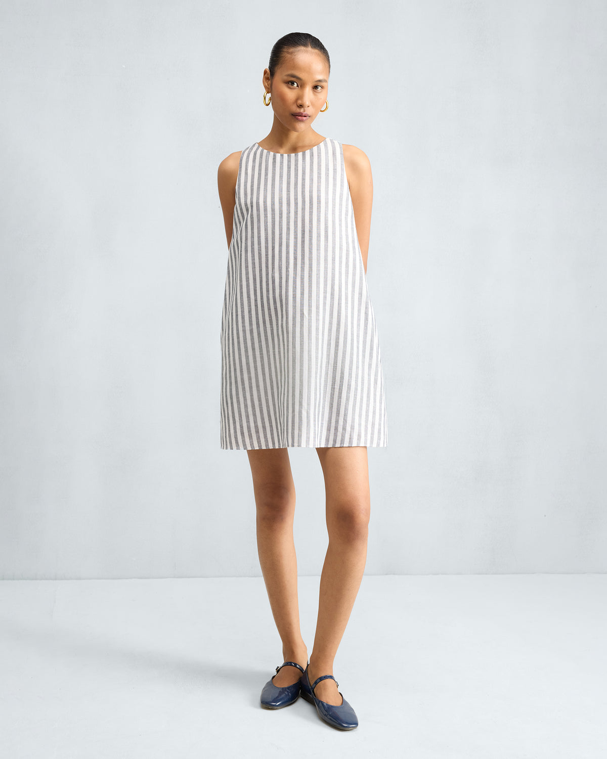 Person wearing a charcoal and white striped short racerback dress.