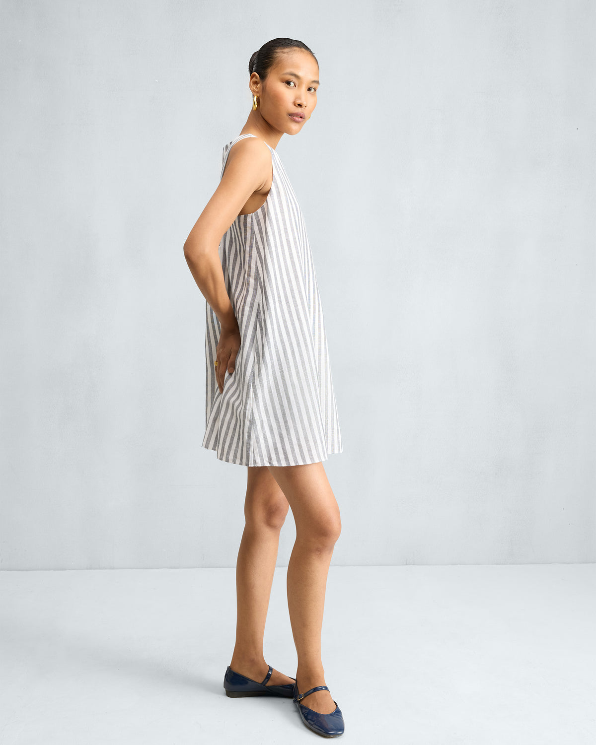 Side view of a charcoal and white short racerback dress with an A-line hem.