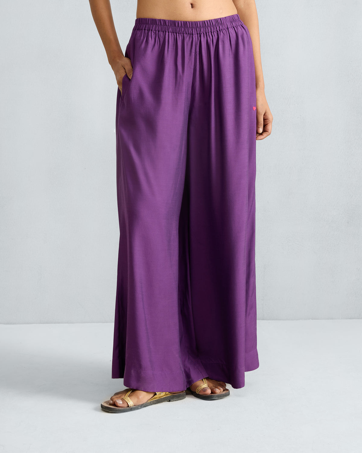 Person wearing purple Classic Pyjama pants with a gathered waist and wide legs.