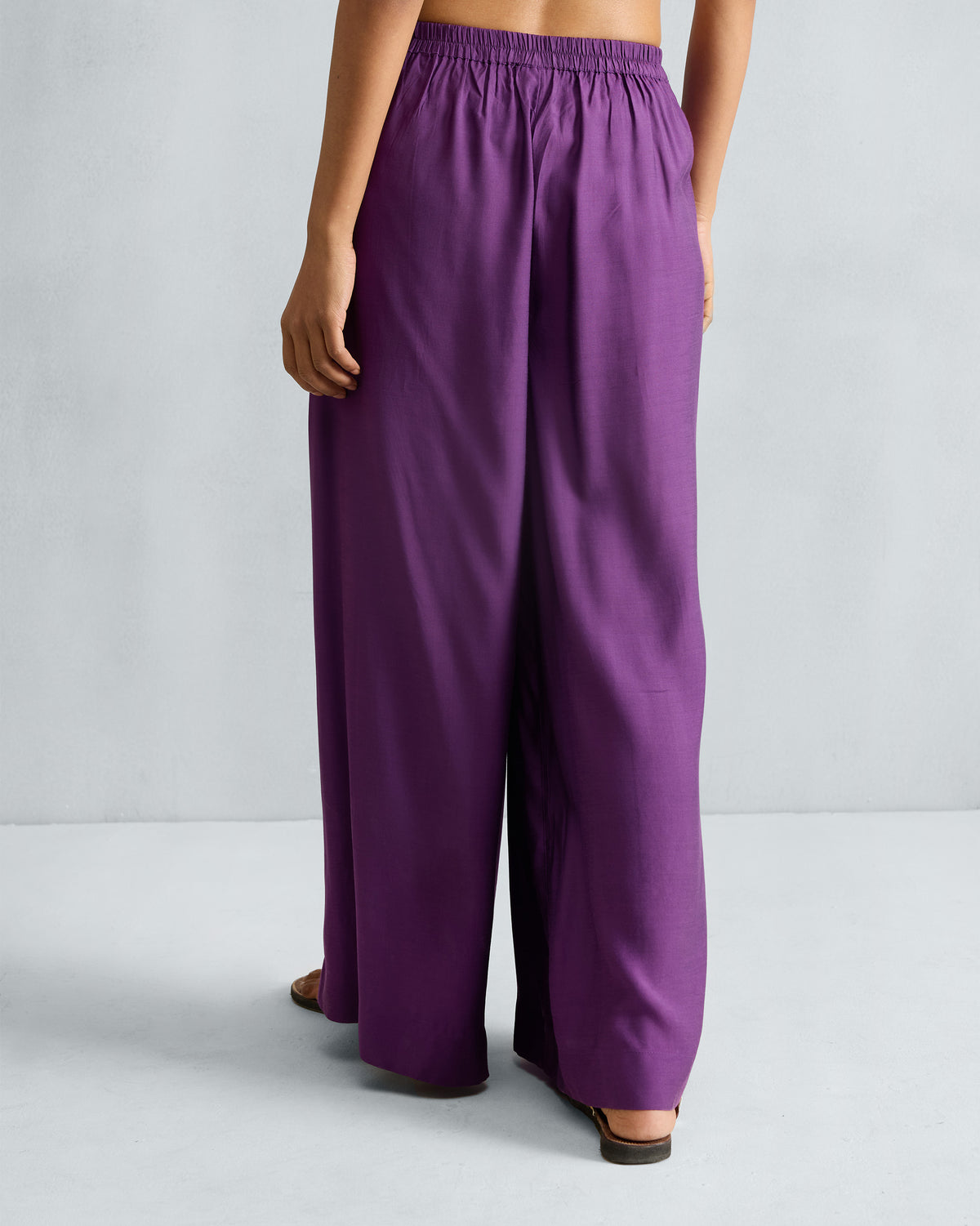Back of purple Classic Pyjama pants with a gathered waist and flowing wide legs.