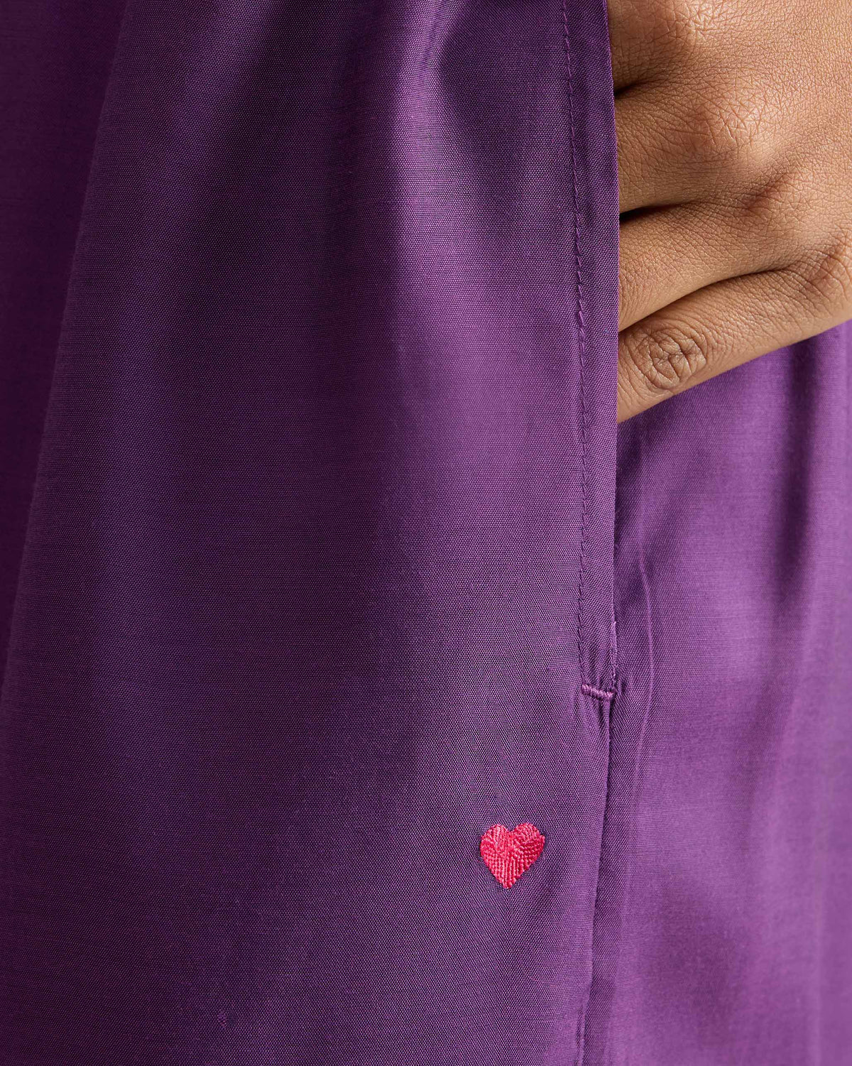 Close-up of purple Classic Pyjama pants with a side pocket and pink heart embroidery.