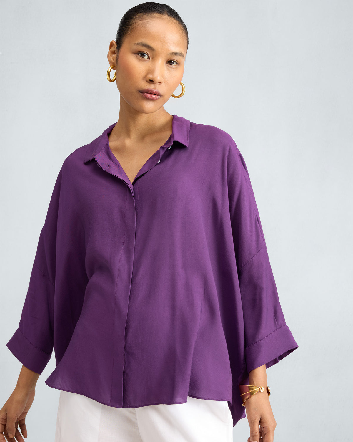 Person wearing a purple Boxy shirt with dropped shoulders and wide cuffs.