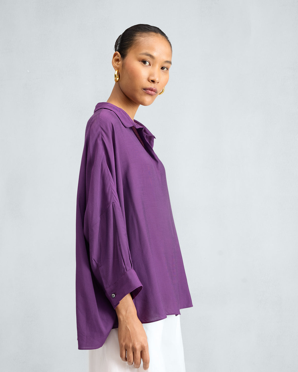 Side view of a purple Boxy shirt with voluminous sleeves.