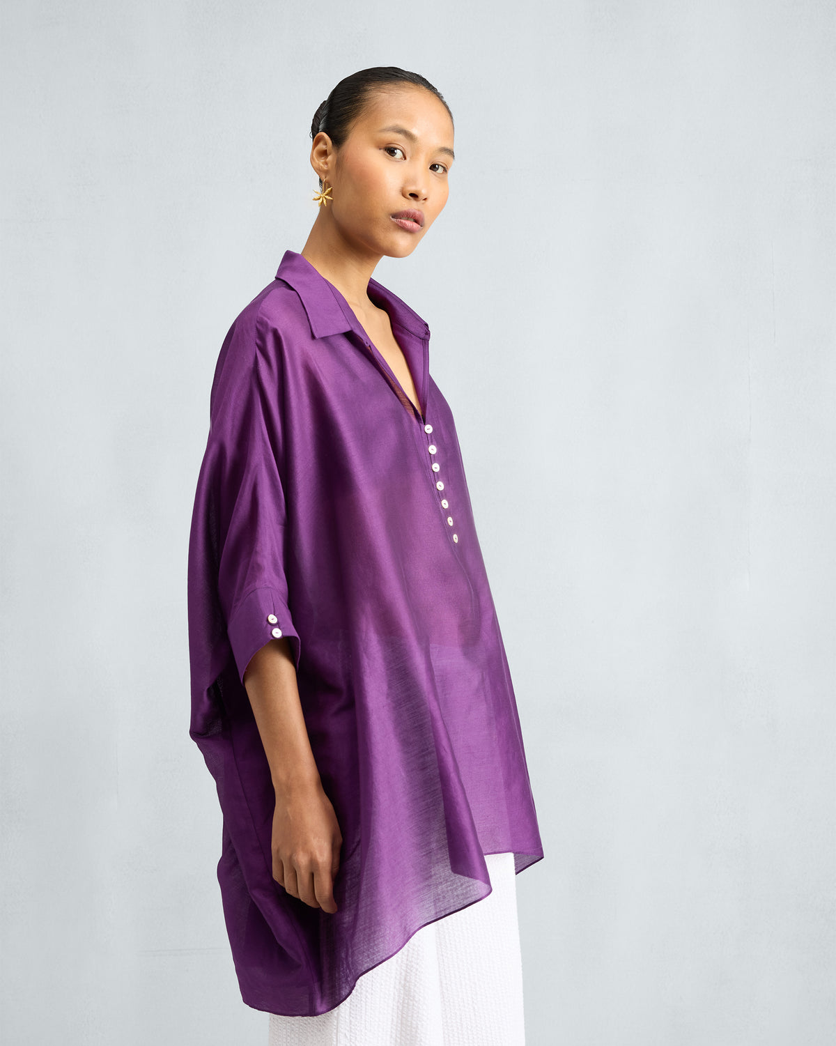 Side view of a purple Hala Tunic with wide, draped sleeves.