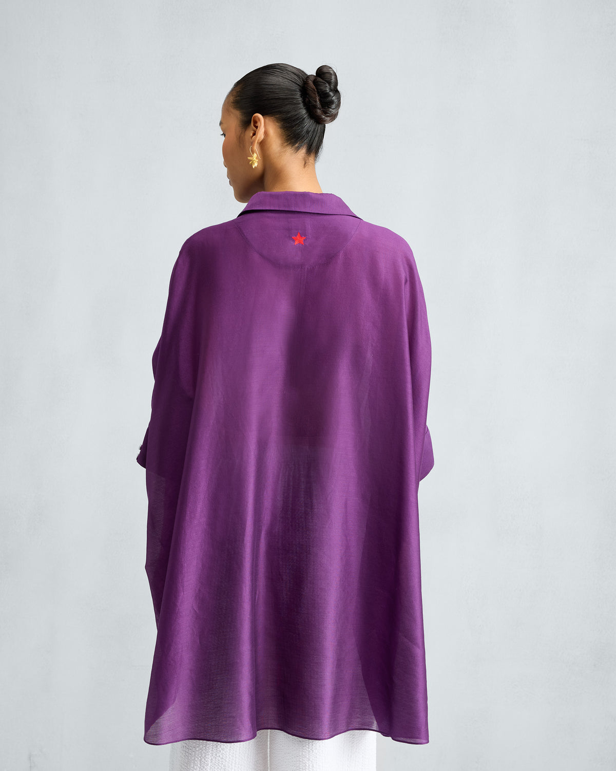 Back of the purple Hala Tunic with a small red star at the yoke.