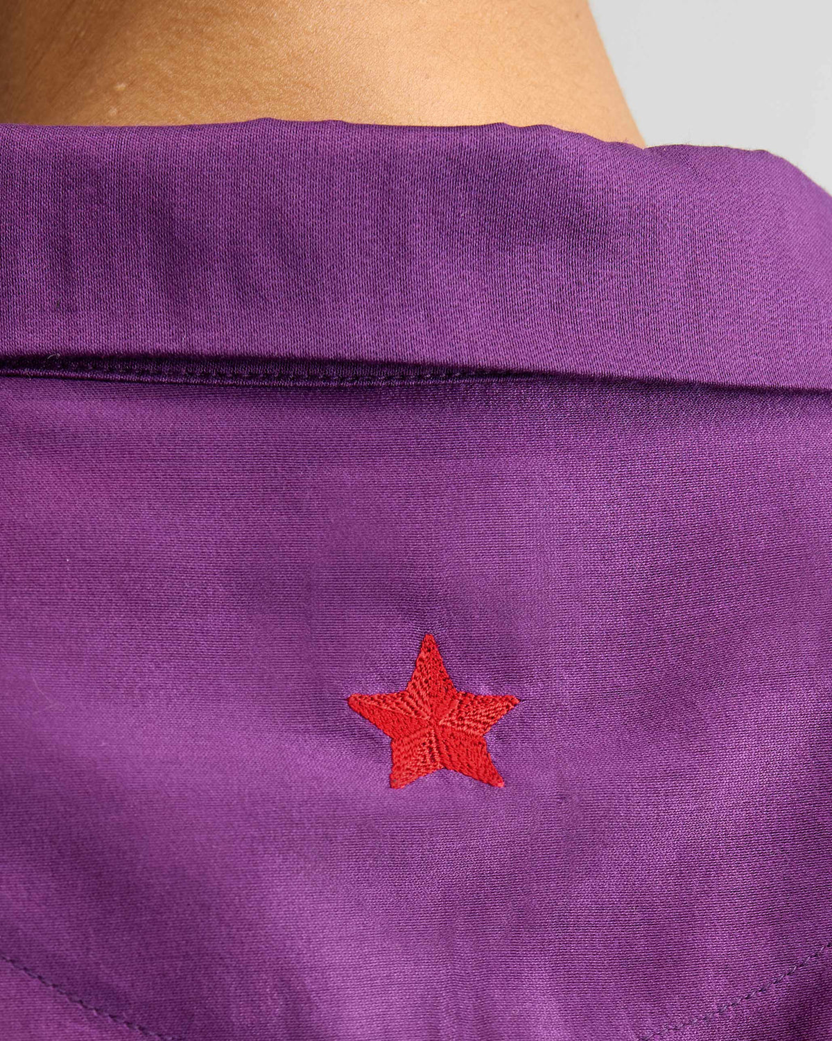 Close-up of the Hala Tunic back yoke showing a red star embroidery.