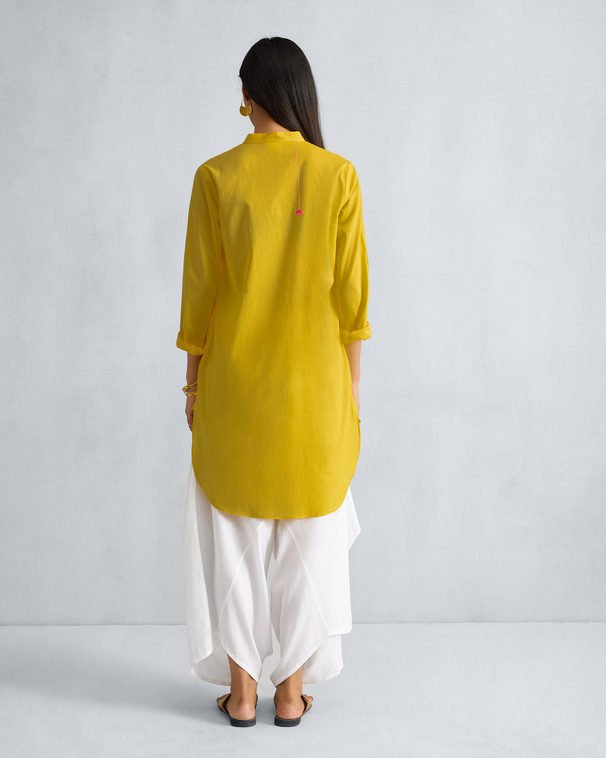Back of a yellow mid-length kurta with a curved hem.