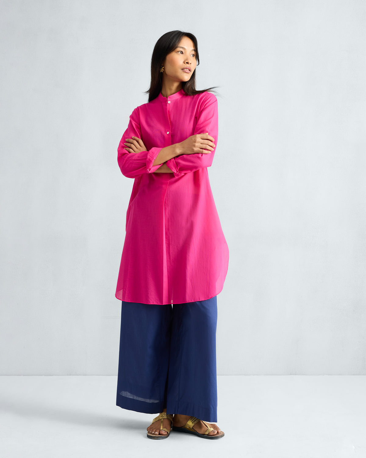 Person wearing a fuchsia mid-length kurta with a mandarin collar.