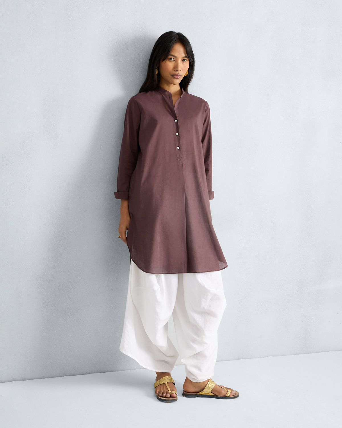 Person wearing a chocolate plum mid-length kurta with a mandarin collar.