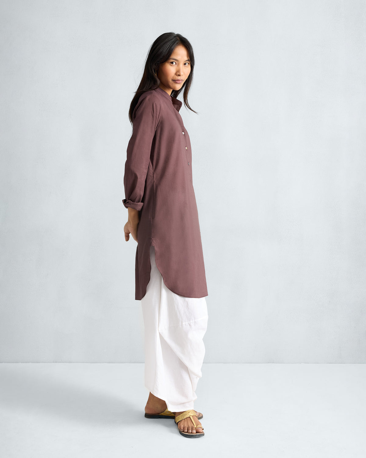 Side view of a chocolate plum mid-length kurta with side slits.
