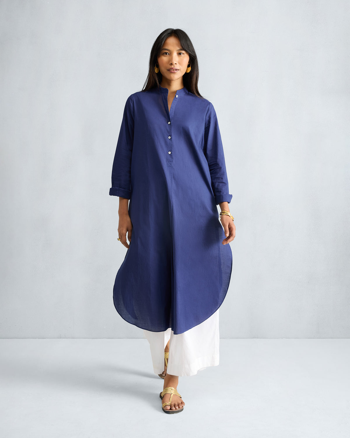Person wearing an ink blue long kurta with a mandarin collar and curved hem.