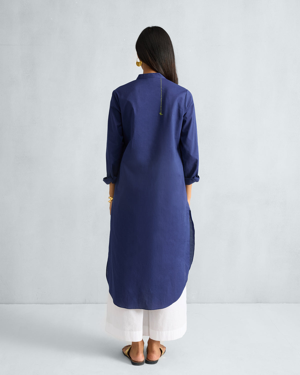 Back of an ink blue long kurta with a curved hem.