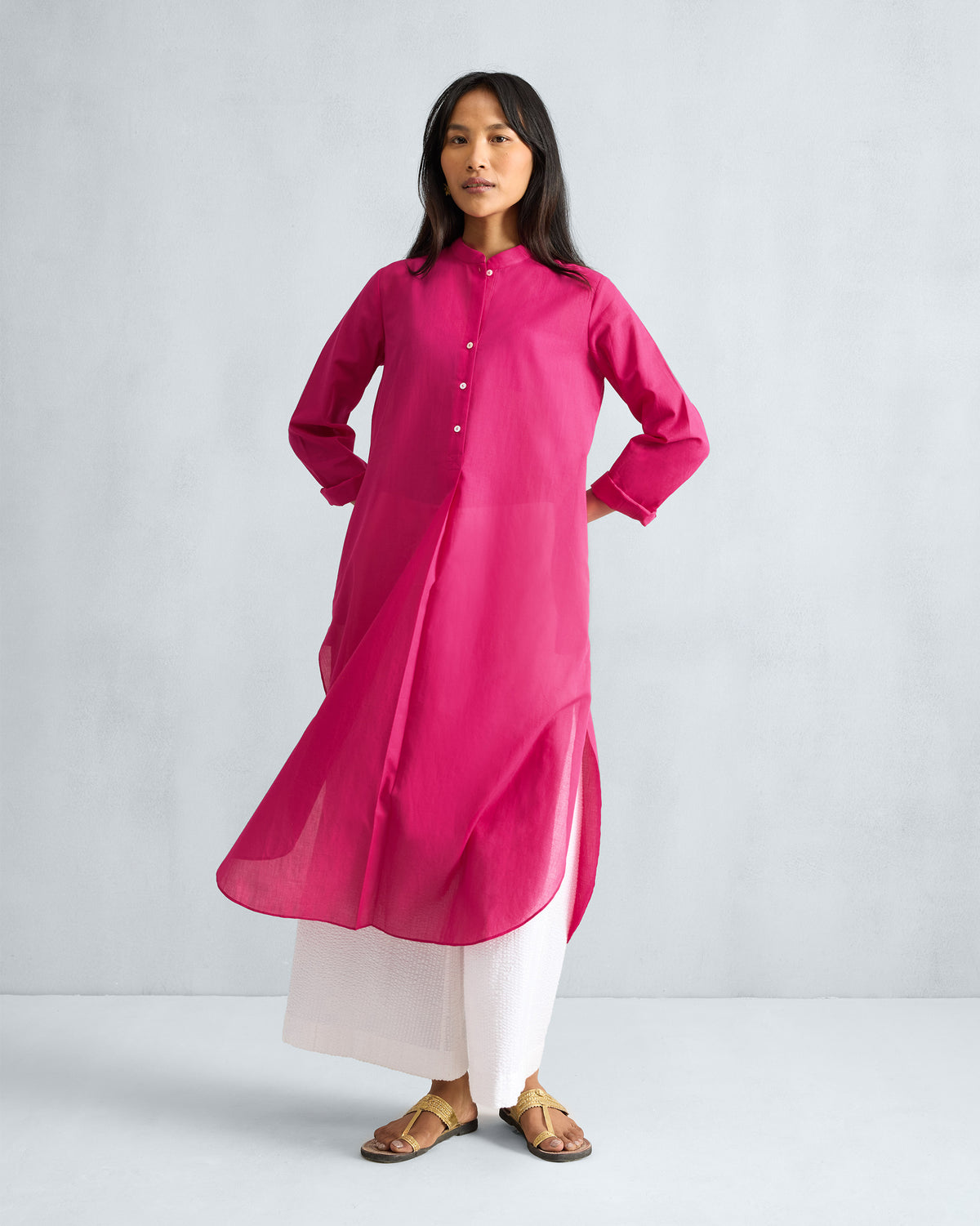Person wearing a fuchsia Basic Long Kurta with a band collar and side slits.
