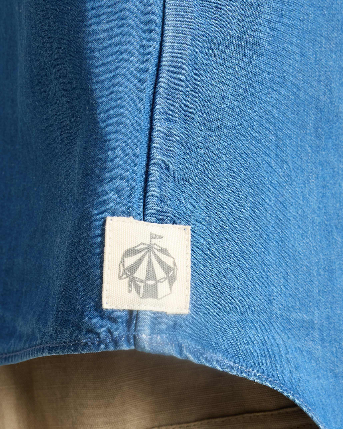Close-up of a side-seam label on a denim Ukiyo racerback tank.