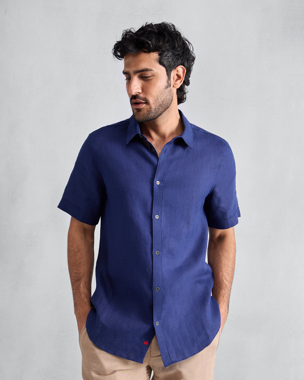 Person wearing an ink blue half-sleeve shirt with a classic collar.