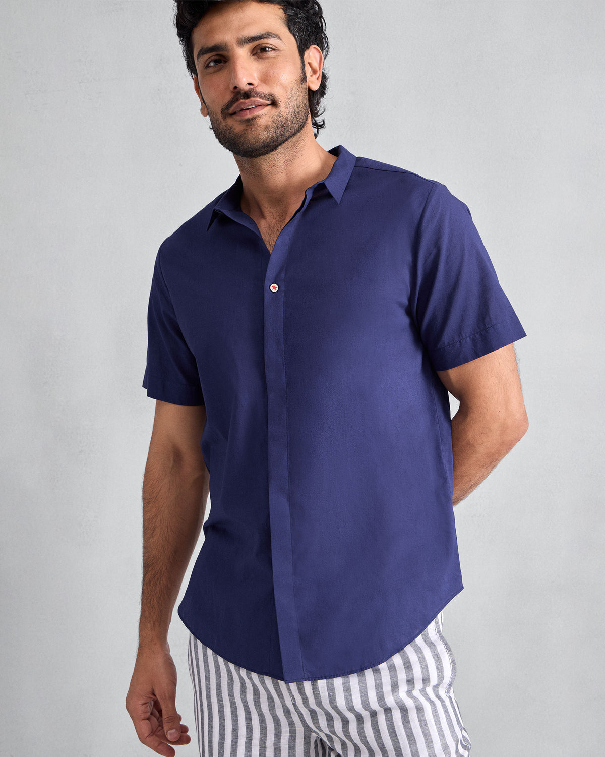 Person wearing an ink blue Riverine Shirt with a concealed placket and accent button.