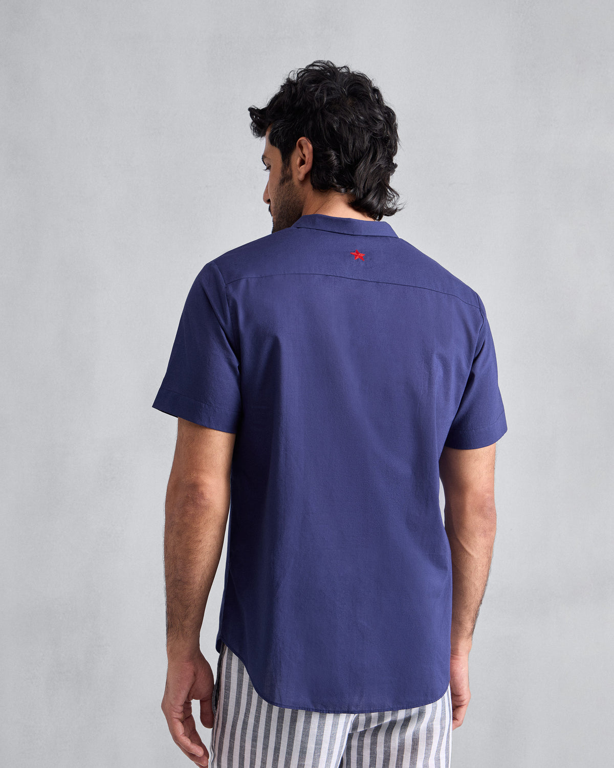 Back of an ink blue Riverine Shirt with a red star on the yoke.