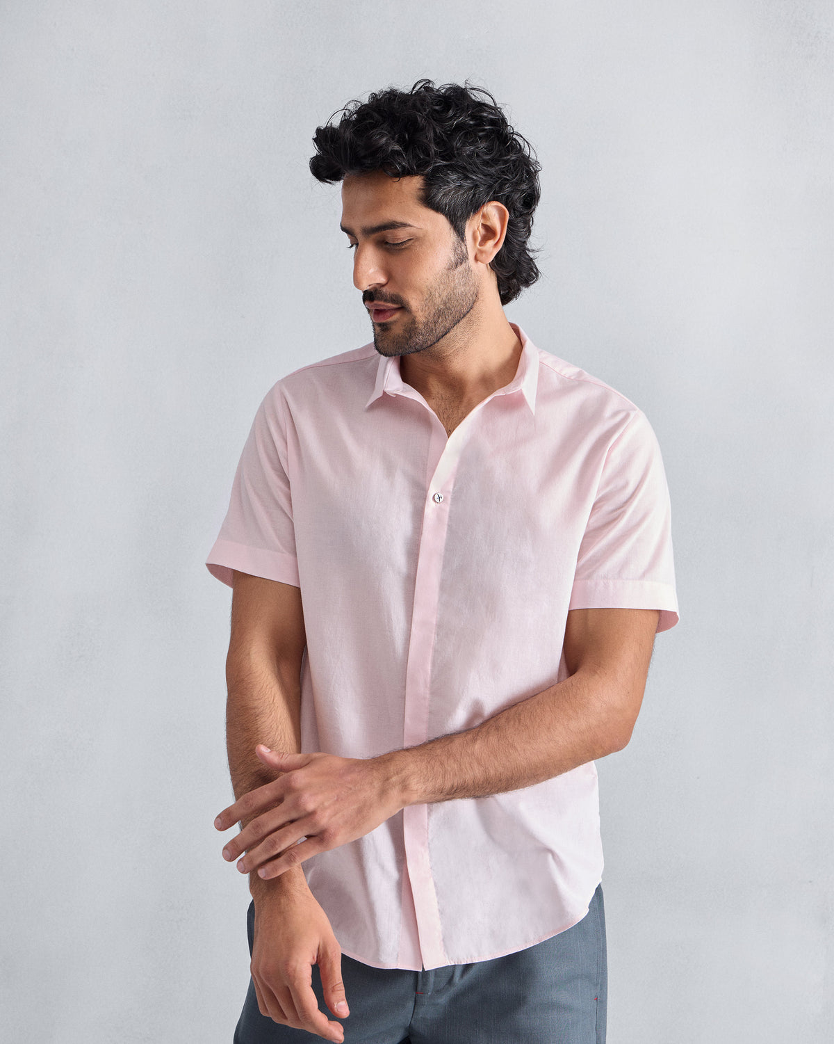 Person wearing a pink short-sleeve Riverine Shirt with a concealed placket.