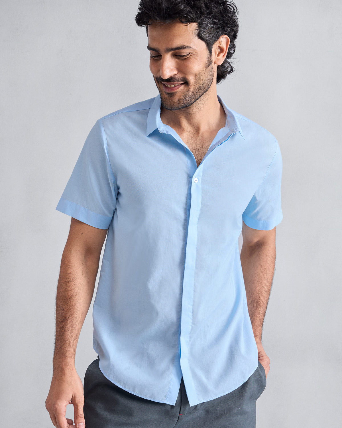 Person wearing a light blue Riverine shirt with a pointed collar.