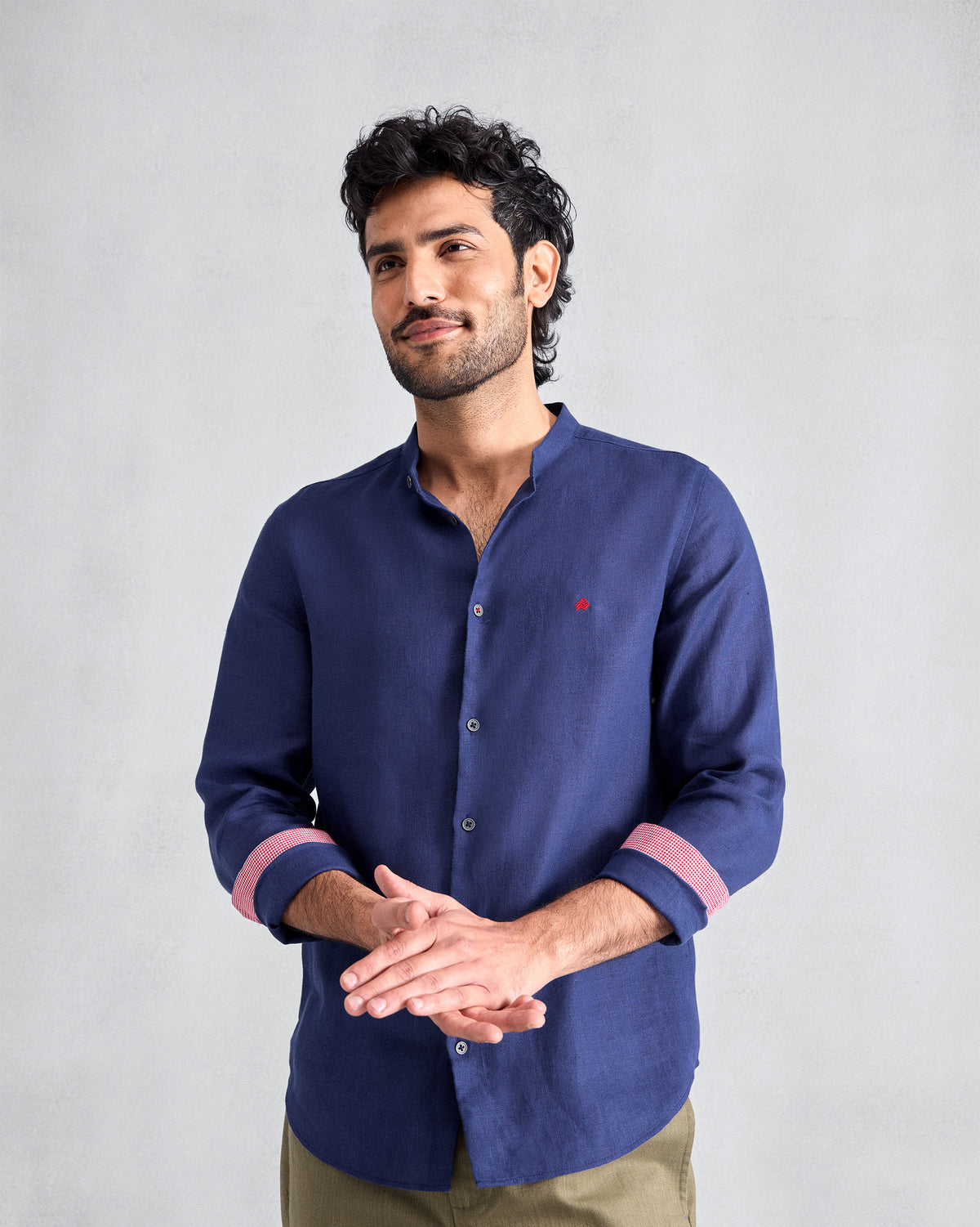 Person wearing an ink blue Nawab shirt with coral cuff lining.