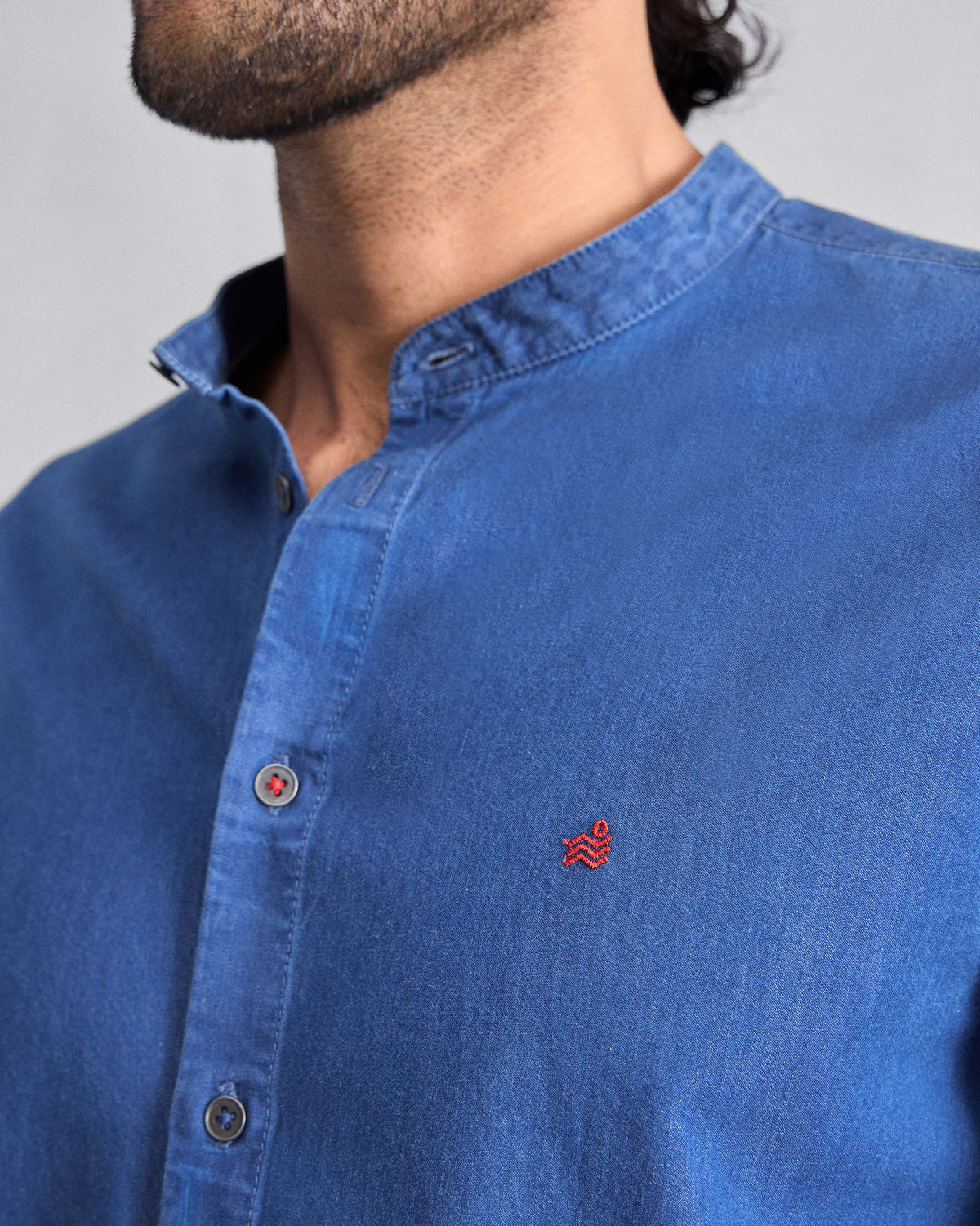 Close-up of a denim Nawab Shirt showing a Nehru collar and red chest logomark.