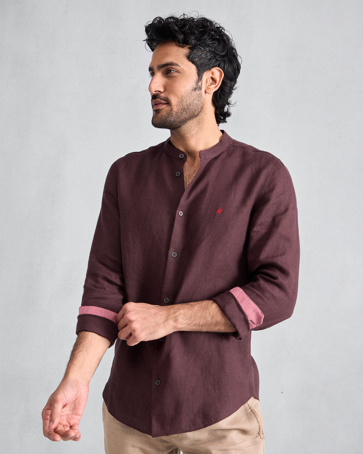 Person wearing a chocolate plum Nawab Shirt with sleeves rolled to show check cuff lining.