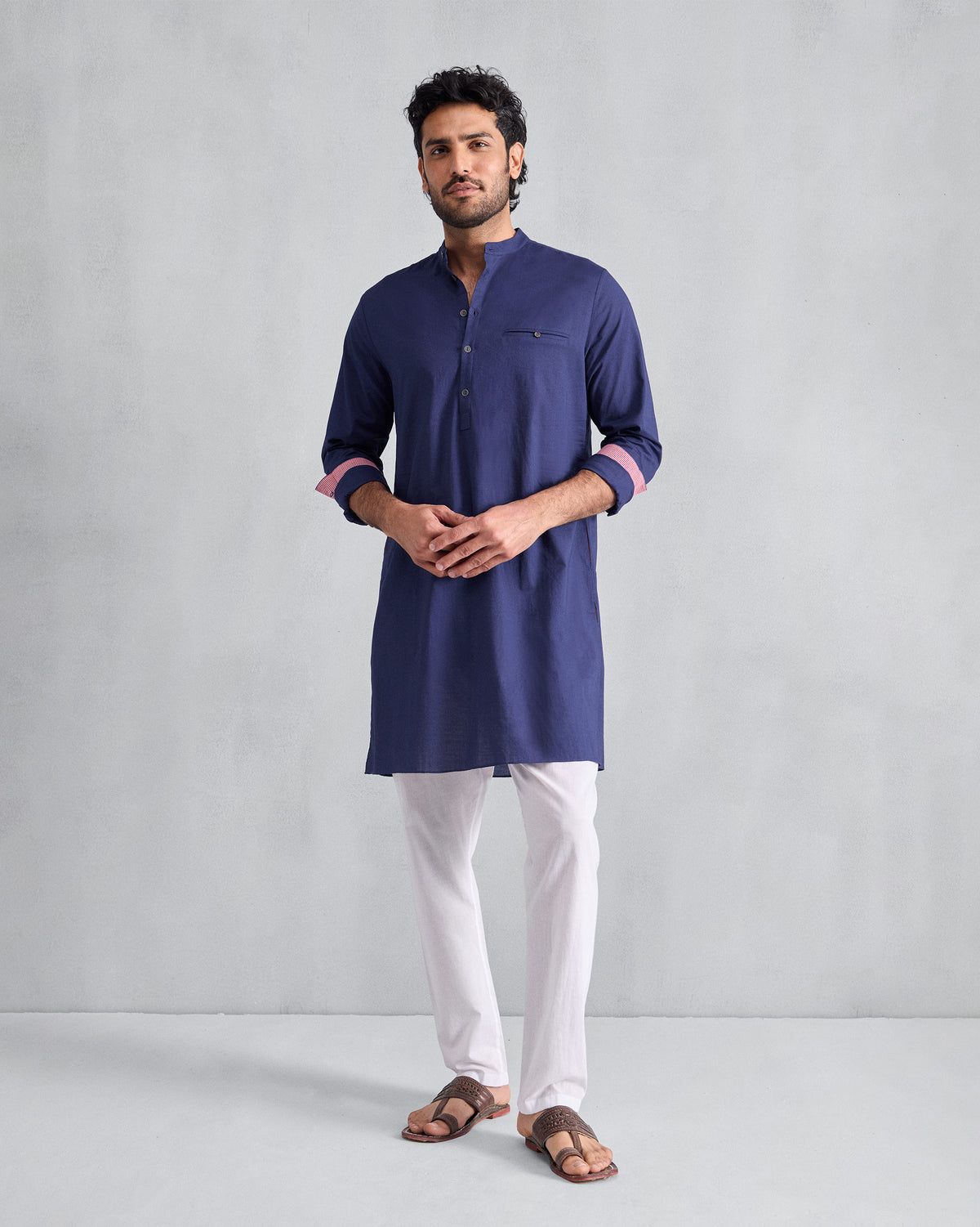 Person wearing an ink blue Pondicherry Kurta with a chest welt pocket.