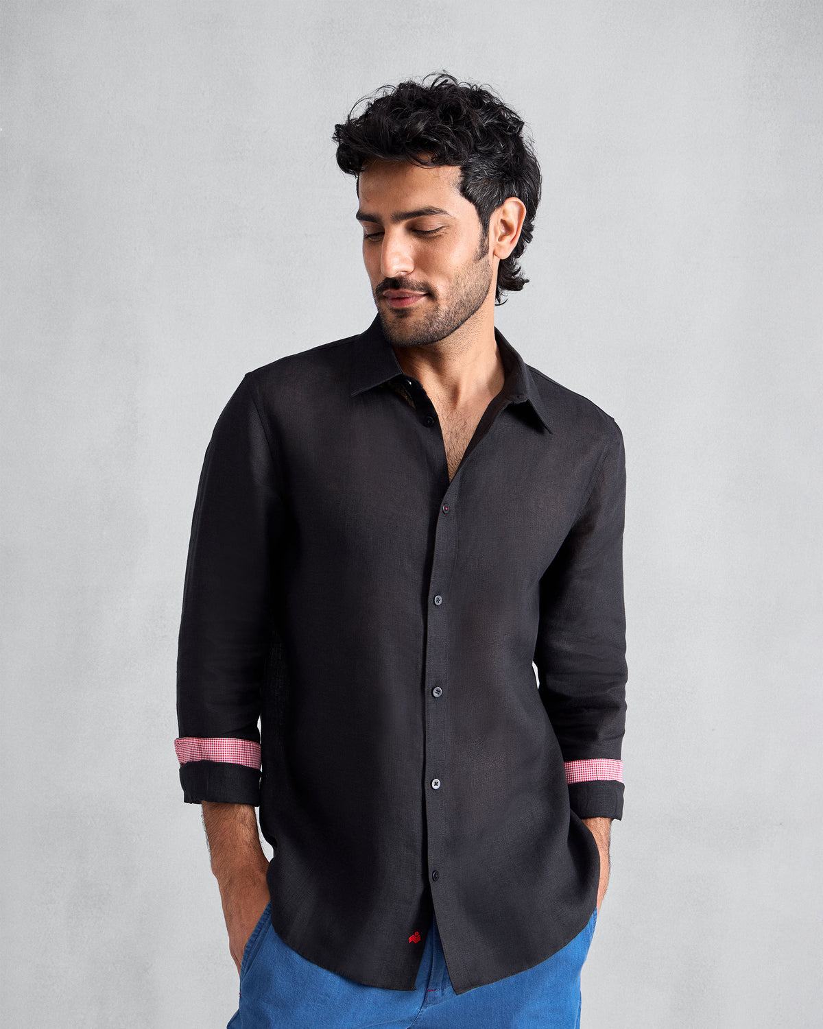 Person wearing a black Classic shirt with pink cuff lining.