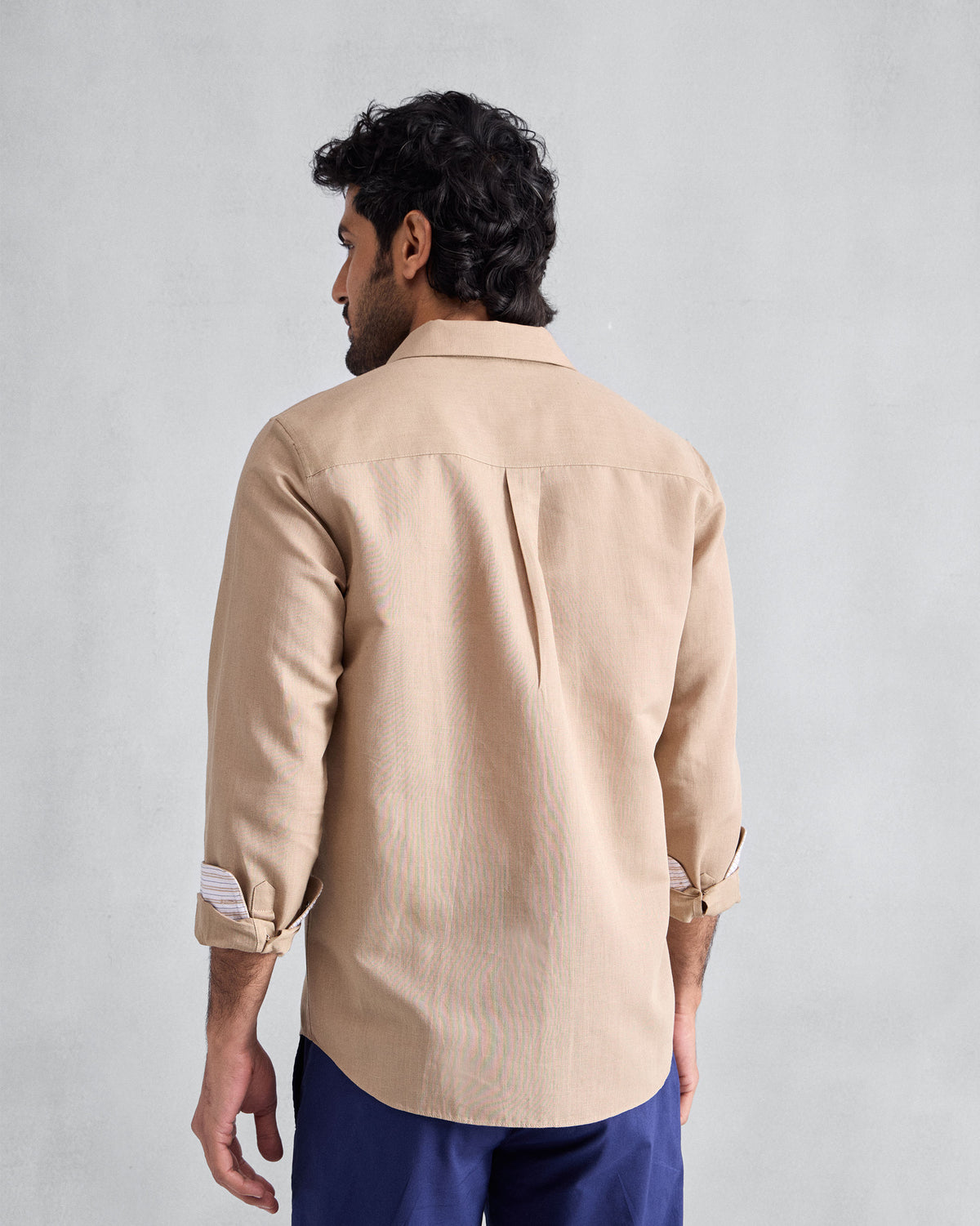 Back of a beige Classic shirt with a center box pleat.