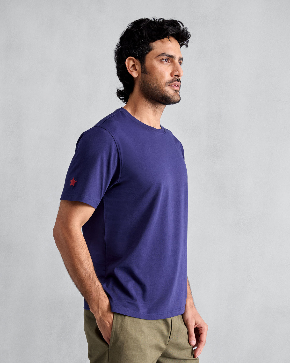 Side view of an ink blue Everyday T-shirt with a red star on the sleeve.