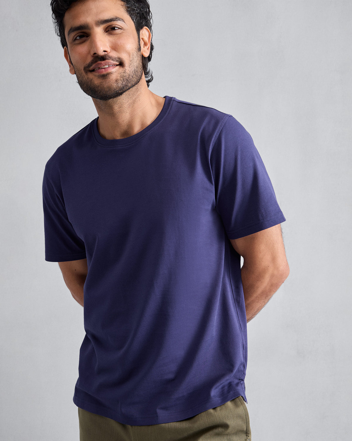 Person wearing an ink blue Everyday T-shirt with a side-slit hem.