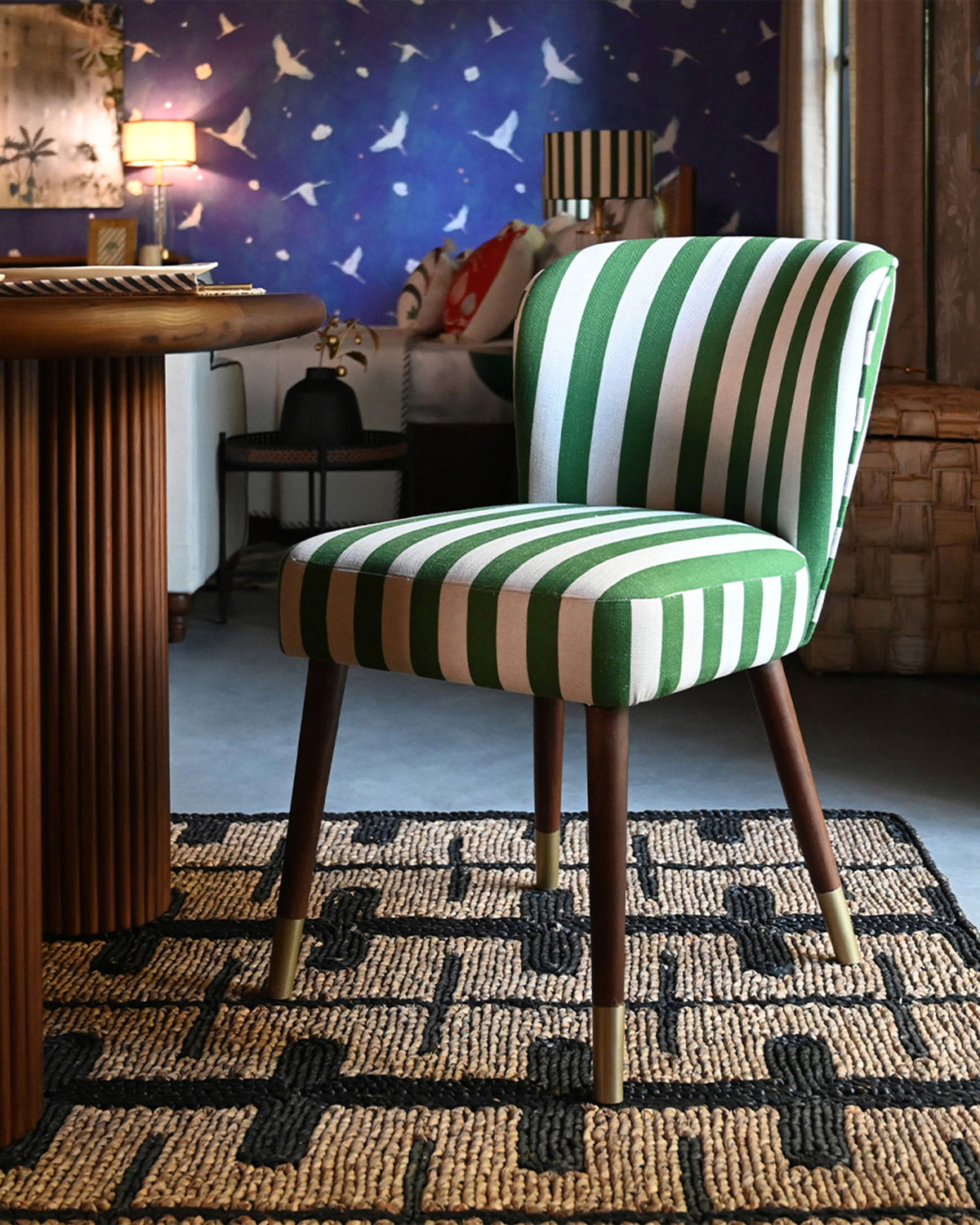 Green-striped Rain dining chair at a wooden table in a styled room.