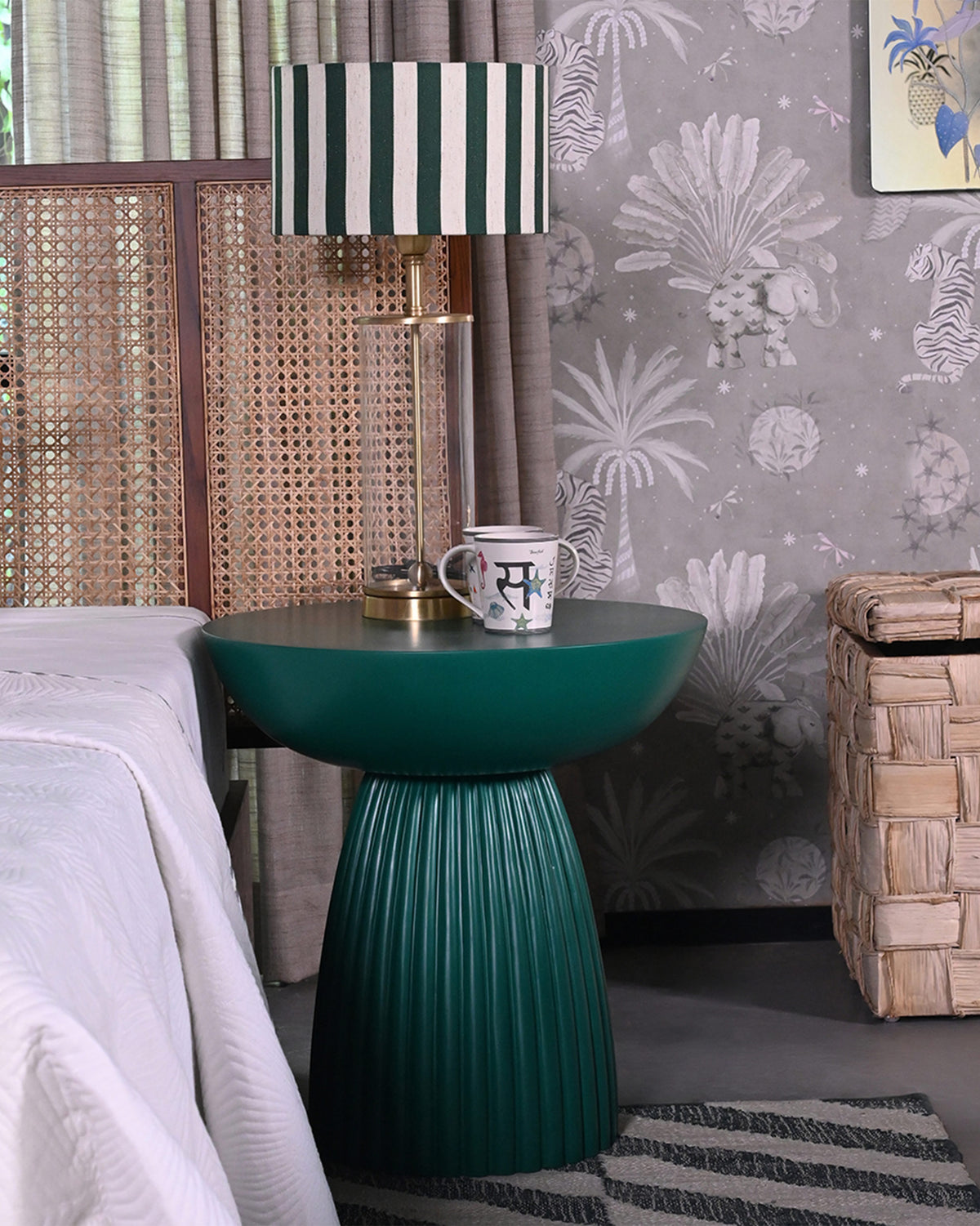 Fern Side Table in green placed beside a bed.
