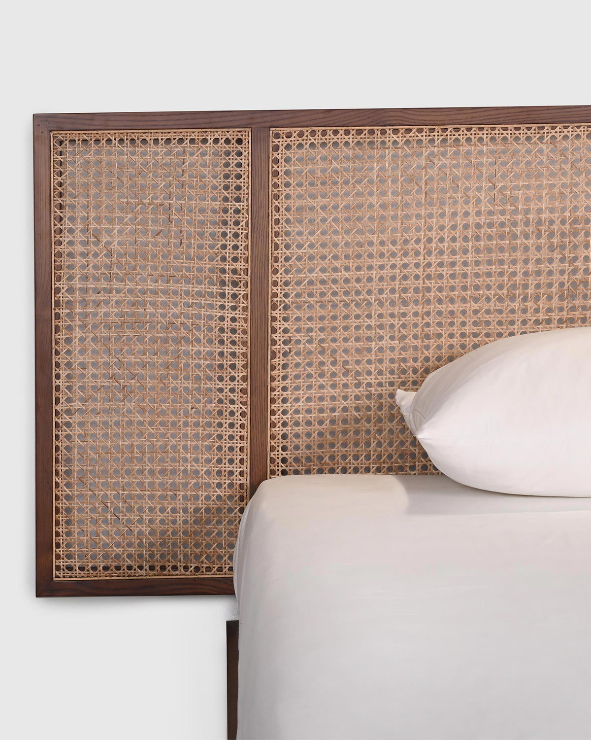 Close-up of the Solstice bed cane weave set in a dark wood frame.