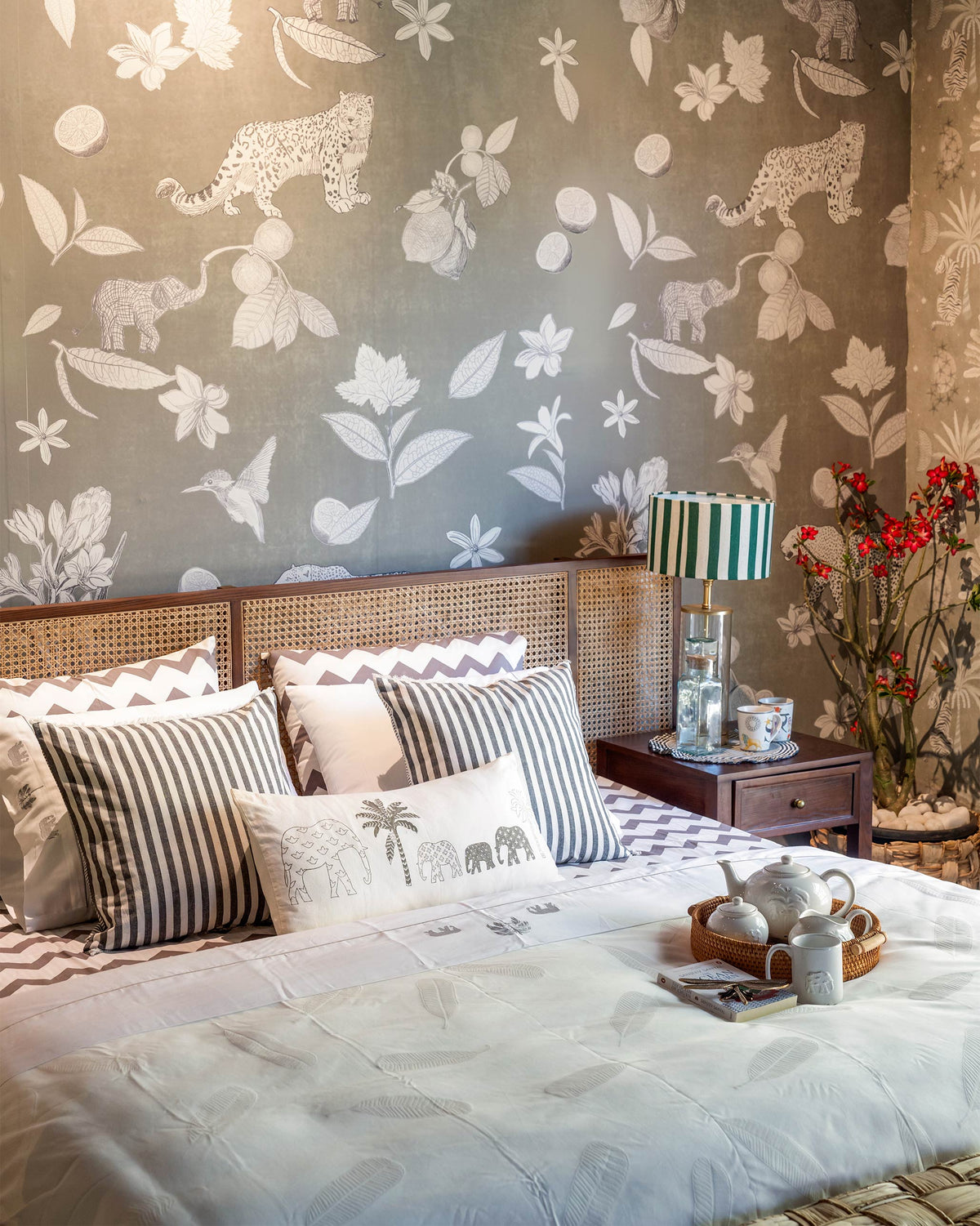 Solstice cane-headboard bed styled in a patterned wallpaper bedroom.