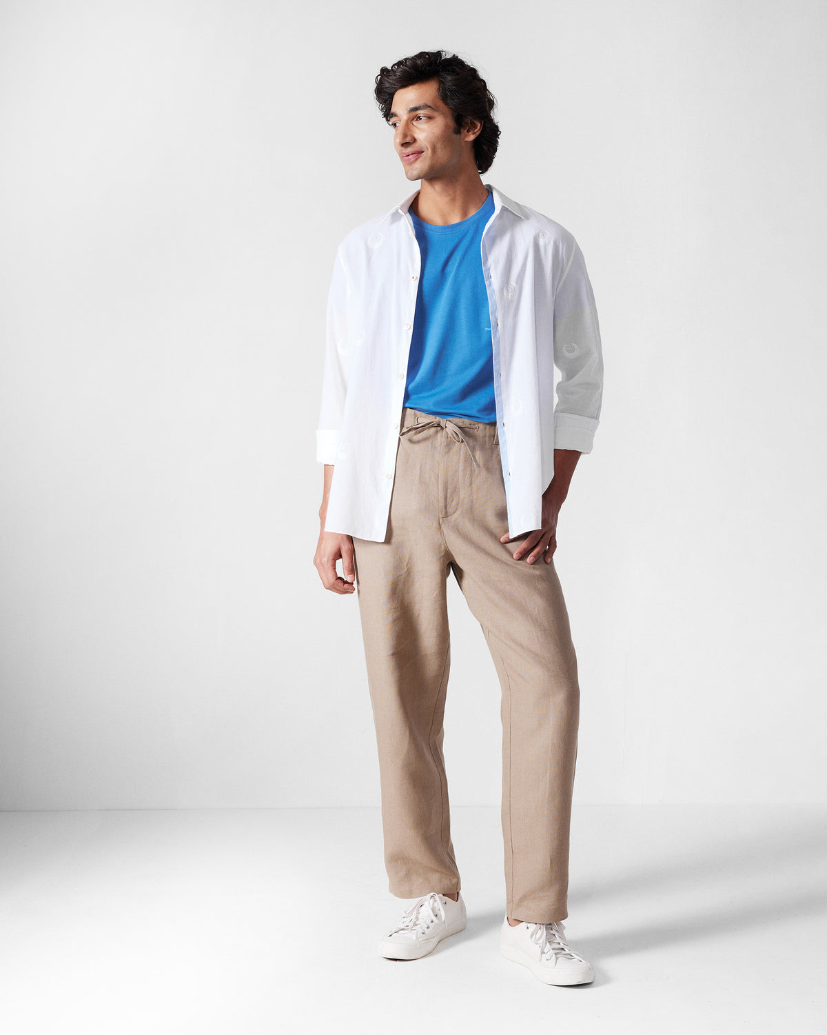 Person wearing a riverside blue Everyday t-shirt under an open white shirt.