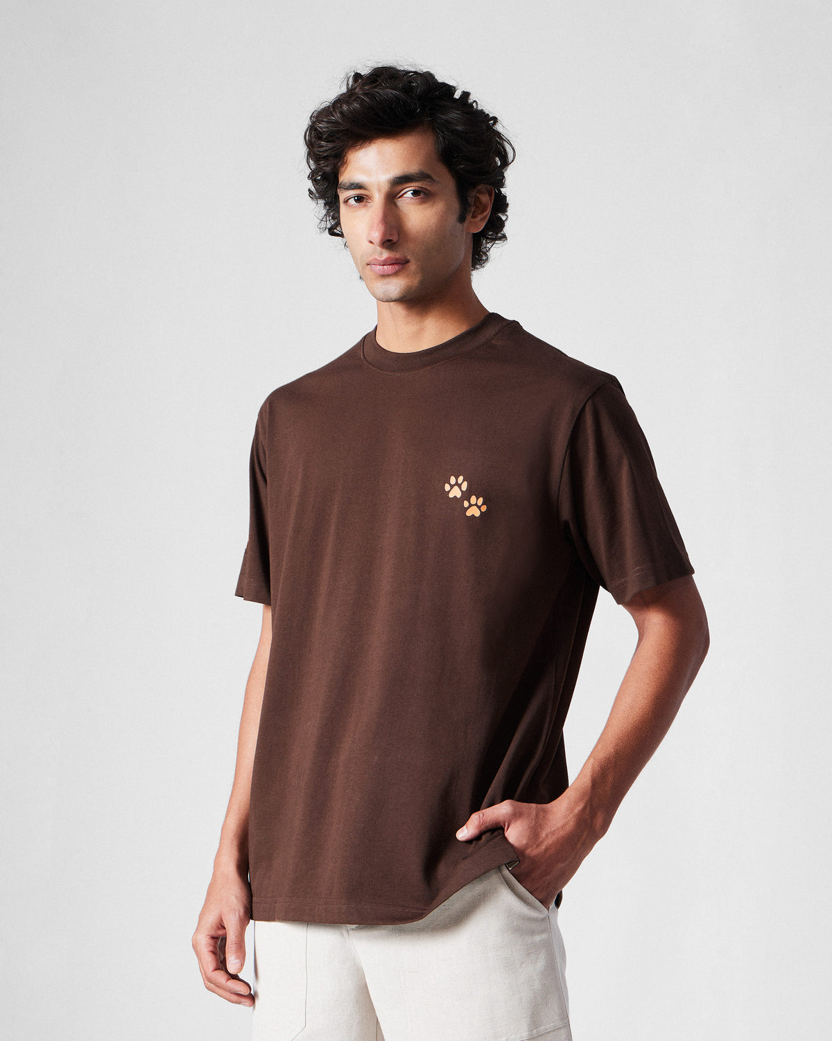 Person wearing a brown Leap t-shirt with peach paw prints.