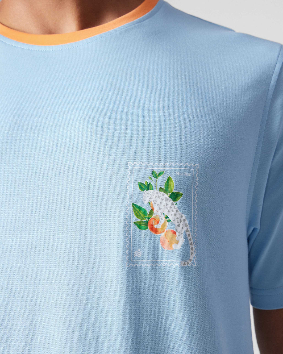 Close-up of an ice blue Everyday T-Shirt showing a leopard stamp graphic.