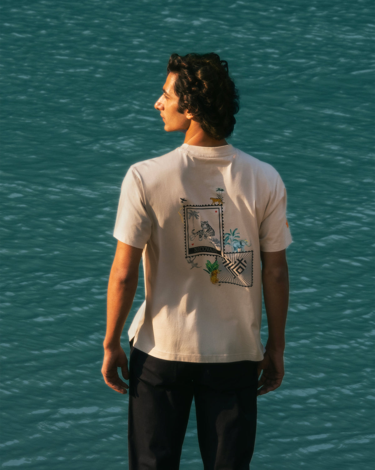 Back of a beige Postal T-Shirt with a tiger postage stamp graphic.