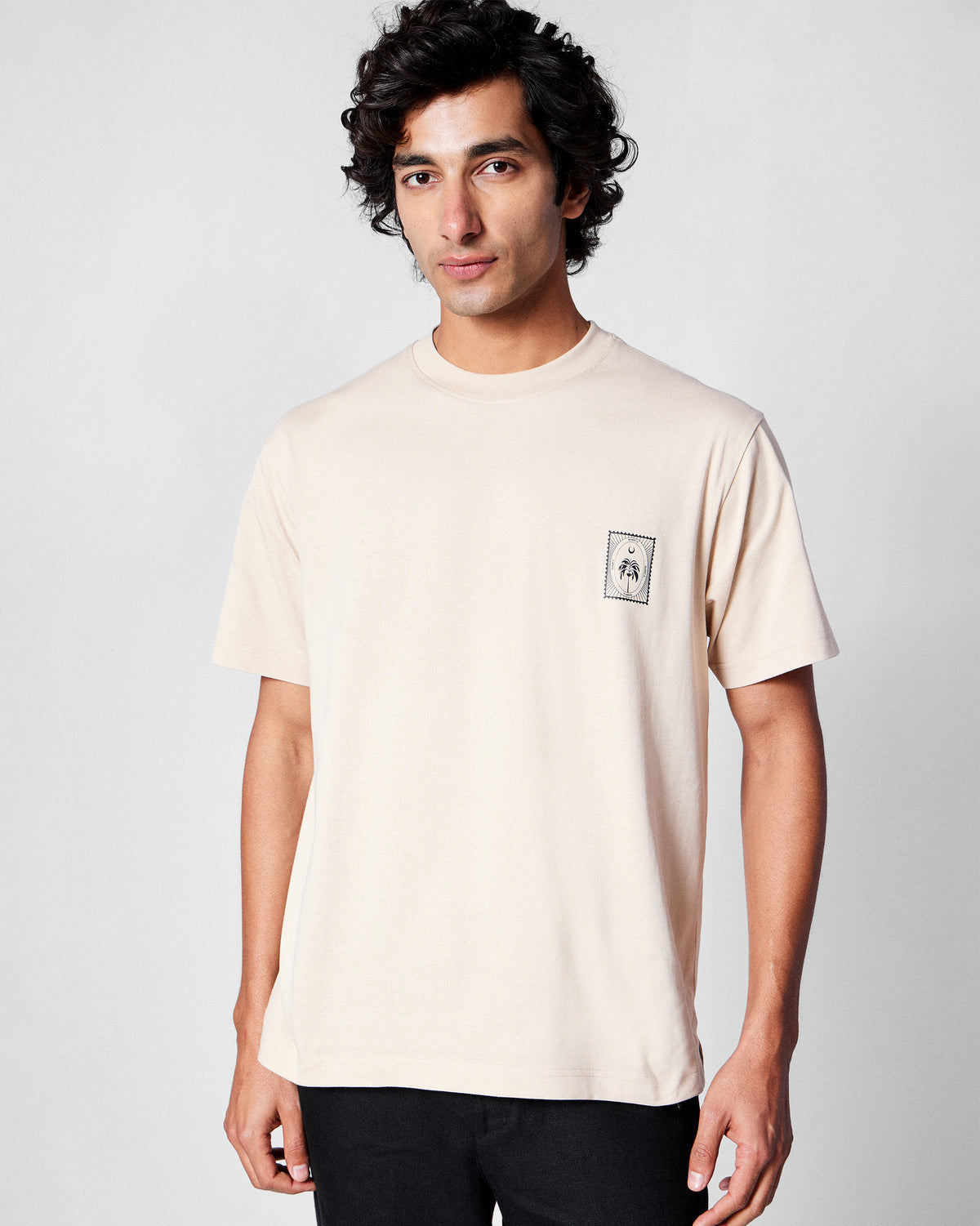 Beige Postal T-Shirt with a palm stamp graphic on the chest.