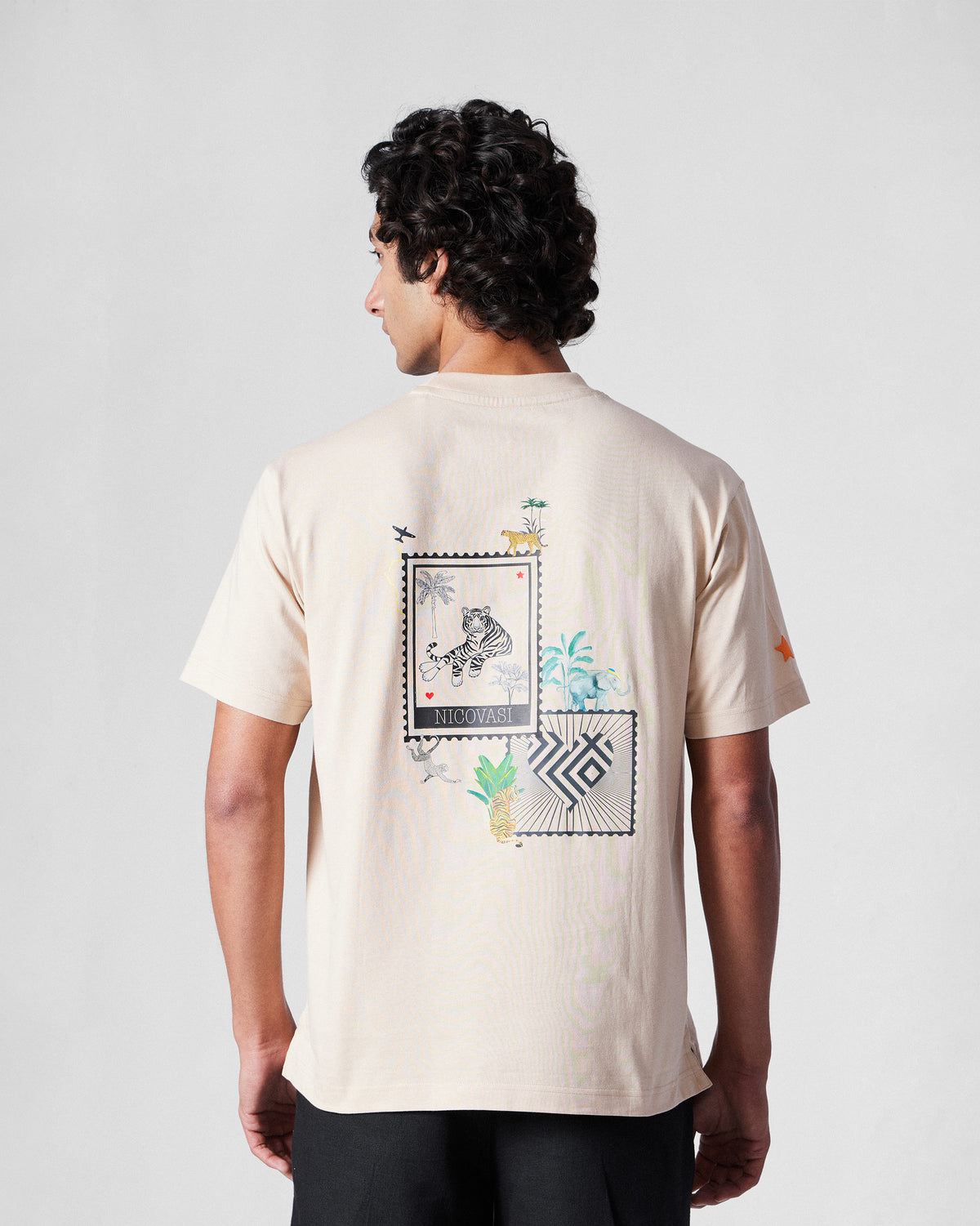 Back of a beige Postal T-Shirt with a postage stamp collage print.